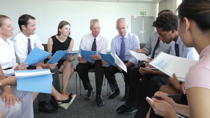 Wall Mural - Group Of Businesspeople Discussing Document Together