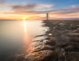 Fototapeta Łazienka - Sunset on the coast, lighthouse windmill in Swinoujscie, Poland. 