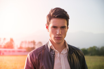 Wall Mural - Handsome young man at countryside, in front of field or