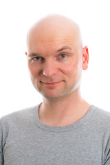 young man with bald head  is smiling in to the camera