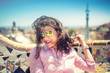 © aboutmomentsimages - Portrait of smiling, gorgeous brunette girl with sunglasses on a windy day. Beautiful woman smiling and playing with hair on rooftop of building