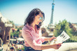 © aboutmomentsimages - Portrait of attractive brunette girl looking at map while travelling. Concept of modern lifestyle with map and travel tips, beautiful woman on rooftop building.