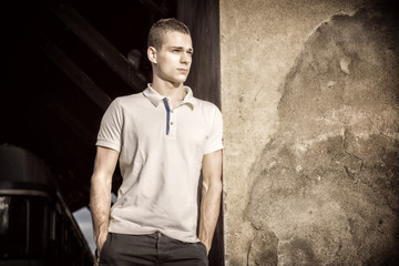 Attractive green eyed young man leaning against wall outside