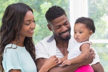 Wall Mural - Happy parents with baby girl 