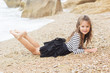 Pretty child girl is wearing stripped dress on the beach