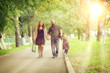 © kichigin19 - Mom and young daughter and dad, a young family on a walk in the park in summer