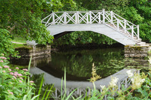 Small Pond And Decorative White Wooden Bridge In Park