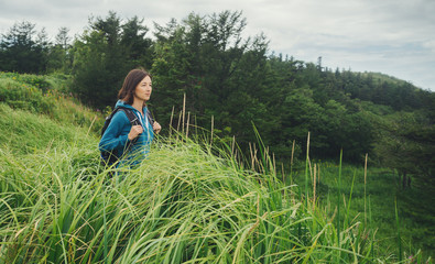 Canvas Print - Tourist young woman walking among high grass