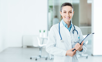 Wall Mural - Smiling female doctor holding medical records