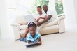 © WavebreakMediaMicro - Pretty couple using laptop on couch and daughter using tablet