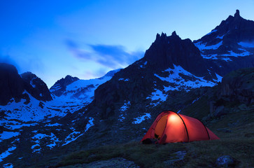 Fototapete - Tent at a mountain campsite in the Alps during an beautiful evening.