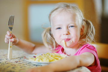 Cute funny girl eating spaghetti