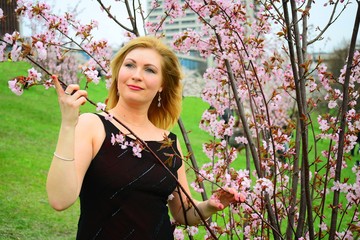 Beautiful female posing in the sakura garden