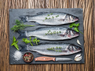 Wall Mural - Seabass on a graphite board with spices and herbs.