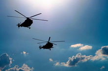Silhouettes Of Two Helicopters Flying