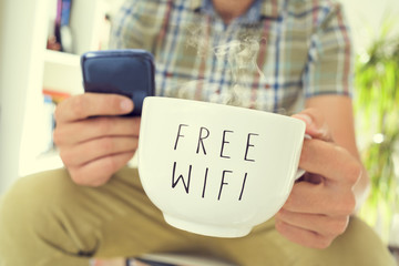 Wall Mural - young man with a smartphone and a cup of coffee with the text fr