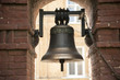 The old bronze bell near the brick wall
