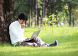 © alexzeer - Young man using his laptop on the grass