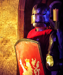 knight in armor with red shield on  background medieval interior