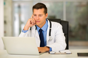 young medical doctor using laptop in office