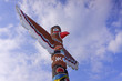 Wooden totem pole under the blue cloudy sky