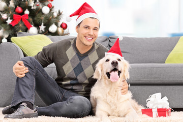 Sticker - Man and a dog with hats sitting by a sofa at home