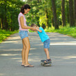 © ruslimonchyk - Mother and son on a skateboard. young mother teaches her little boy to ride a skateboard