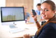 © shefkate - Young woman working in office, sitting at desk, using phone