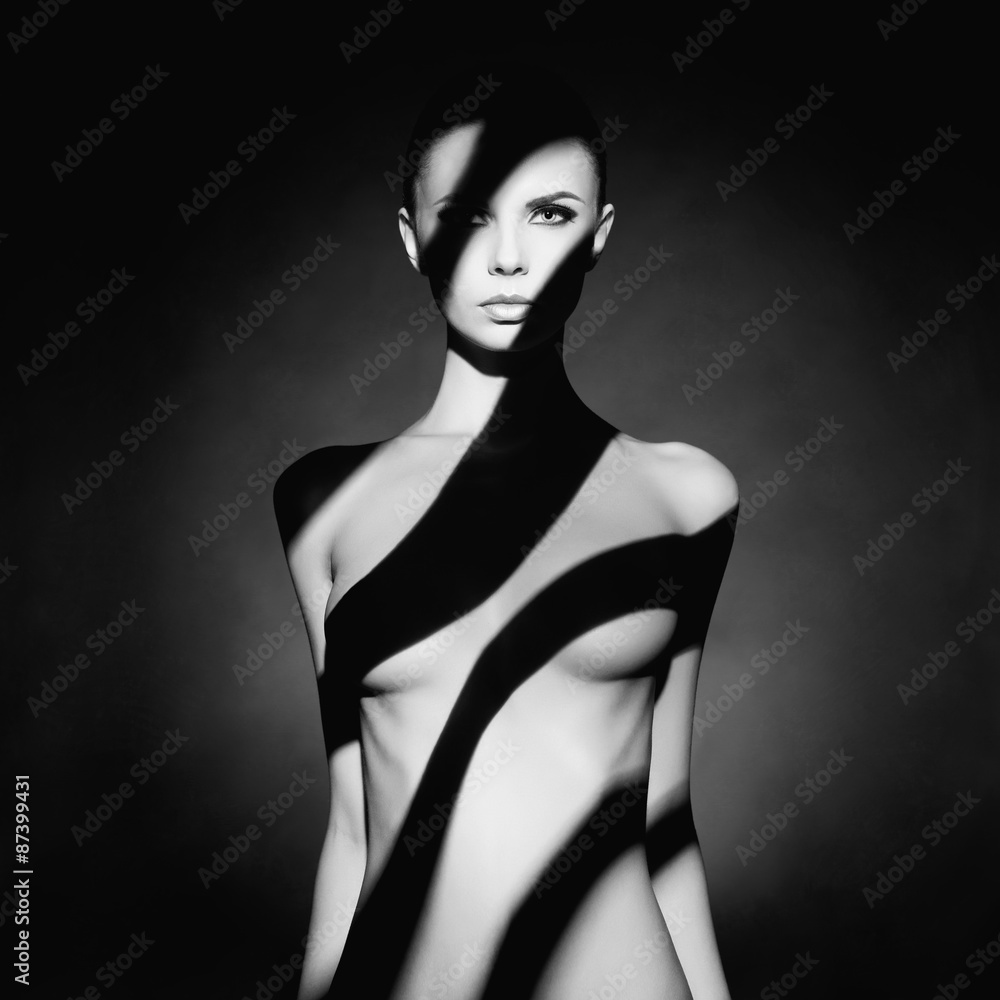 Gorgeous young lady with shadow on her body - obrazy, fototapety, plakaty 