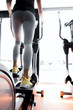 Closeup shot of legs of a female using elliptical trainer