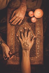 Drawing process of henna menhdi ornament on woman's hand