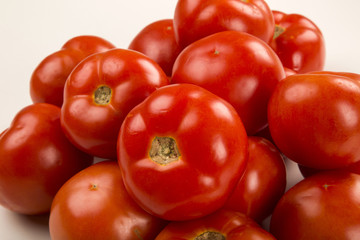 Some tomatoes over a wooden surface on a tomato field as backgro