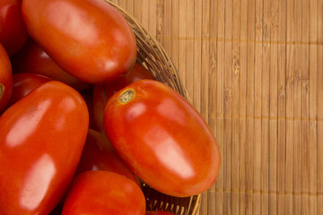 Some tomatoes over a wooden surface on a tomato field as backgro