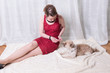 © Jürgen Hüls - woman in red dress feeding dog on blanket