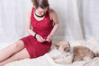 © Jürgen Hüls - woman in red dress feeding dog on blanket