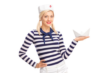 Poster - Young female sailor holding a small paper boat