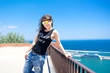 © aboutmomentsimages - portrait of attractive funky girl on top of docks, seaside view.