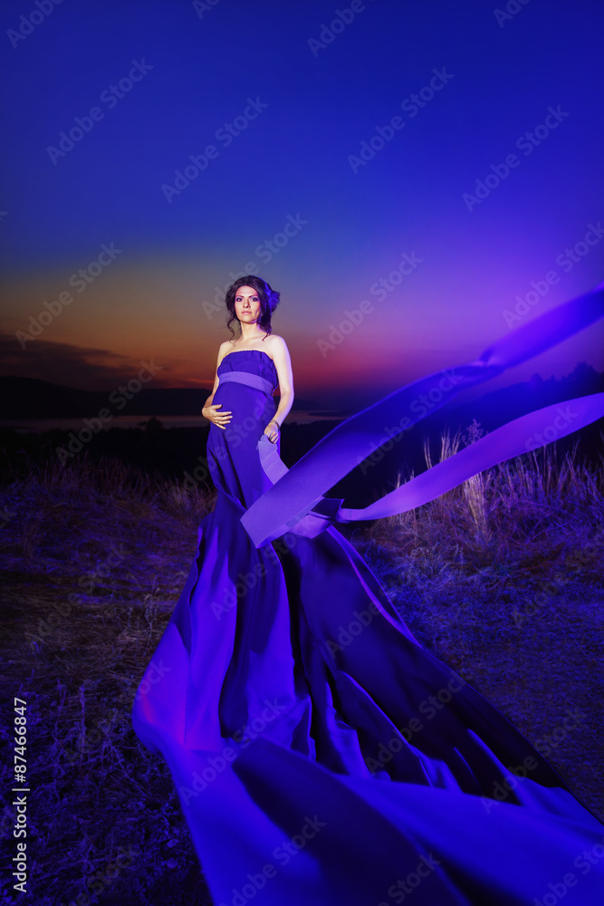 Portrait of beautiful woman in blue clothes standing at top hill - obrazy, fototapety, plakaty 