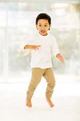 Wall Mural - little indian boy jumping on bed