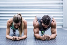 Muscular Couple Doing Planking Exercises