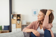 © contrastwerkstatt - junge frau sitzt zuhause auf dem sofa und entspannt