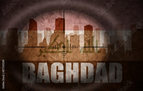 Fotografia, Obraz sniper scope aimed at the abstract silhouette of the city with text Baghdad at the vintage iraqi flag