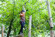Adventure climbing high wire park - woman on course in mountain