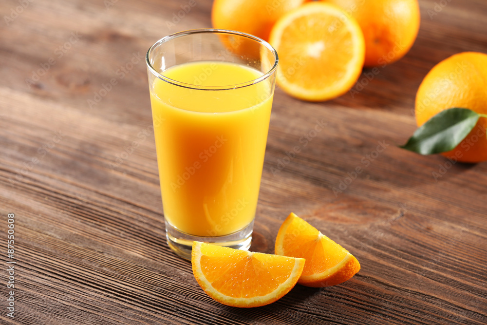 Orange juice on table on wooden background