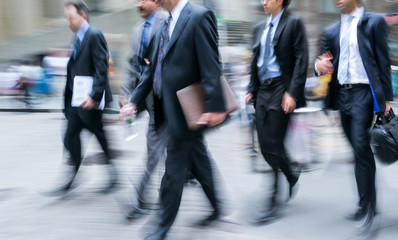 motion blurred business people walking on the street