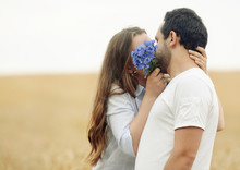Sensual Young Couple Hiding A Kiss Behindthe Flowers