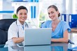 © WavebreakmediaMicro - Doctor and nurse looking at laptop and smiling at camera