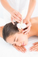 Wall Mural - Beautiful woman receiving ear candle treatment at spa center