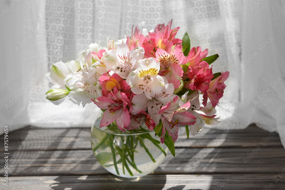 Beautiful bright bouquet in vase on fabric background