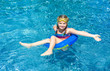 © oksanatrautwein - Smiling little girl  with blue life ring has fun in the swimming pool